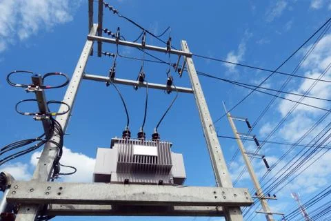 High voltage transformers with power lines and blue sky background Foto stock