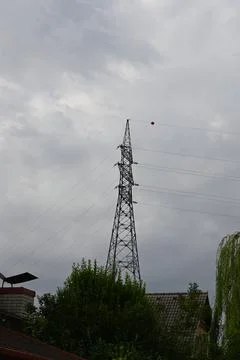 High-voltage transmission tower under cloudy sky Stockfoto's