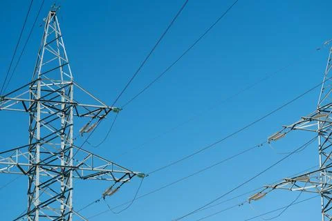 High voltage transmission towers with multiple overhead power lines against.. Stock Photos