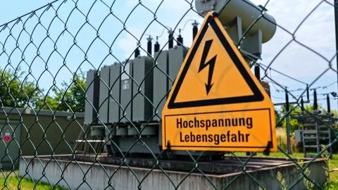 High Voltage Warning Sign in Front of Electrical Transformer Stock Photos