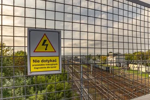 High voltage warning sign, warning sign hanging above the railway tracks Pola Stock Photos