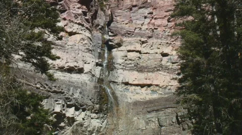 High waterfall cascades down multicolored cliff Stock Footage 113118