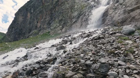 A high waterfall falling from a steep cliff flow of glacial water in mountains Stock Footage 263980675