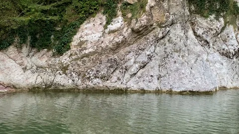A high waterfall falls from a cliff into a clear lake. Sochi, Russia Stock Footage 117483499