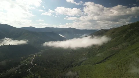 High wide aerial of low clouds in Sawtooth Mountains near Stanley Idaho Stock Footage 280258916