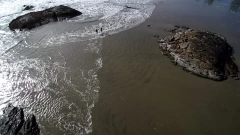 High Wide Drone Shot Of Two Surfers Running Into Cold Water 1 Video stock 144952275