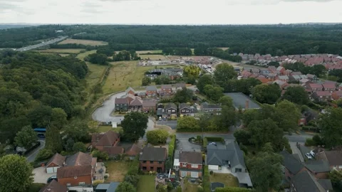 High wide move over a local village towards a new housing development Stock Footage 296822899