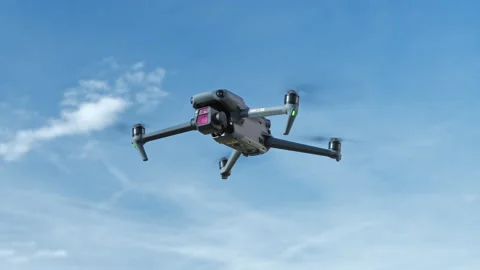 Highend consumer drone Mavic 3 from DJI hovering in front of a blue sky, 6k Stock Footage 170391064