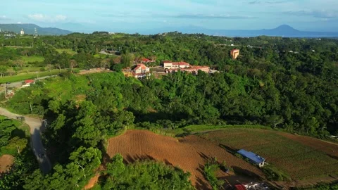 Higher rotating aerial showcasing chapel above mountains and thriving farm Vídeos de archivo 331074287