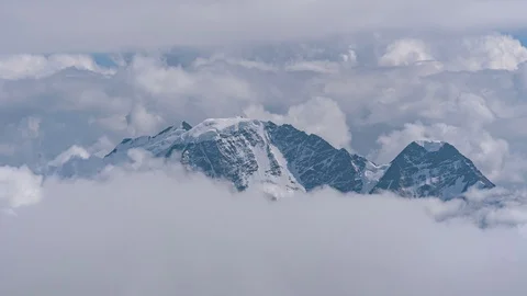 Highest snowy mountain in floating clouds. beautiful timelapse in 4k. nobody. Stock Footage 120475695