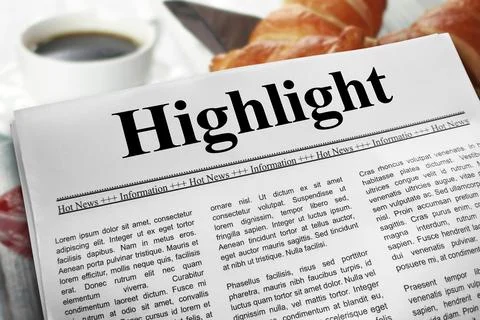 Highlight in newspaper layout on a breakfast table with a blurry cup of cof.. Stock Photos