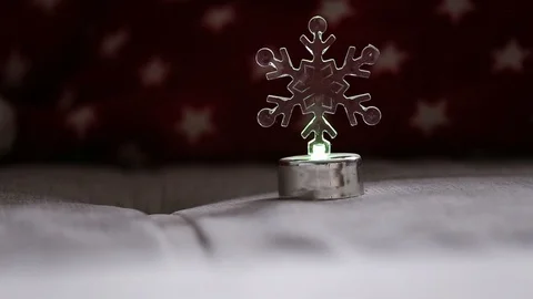 Highlighted artificial snowflake standing on a sofa and changing colors Stock Footage 119869976