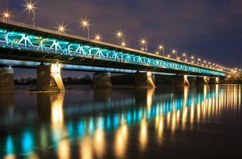 Highlighted bridge at night and reflected in the water Stock Photos