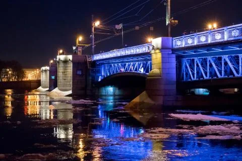 Highlighted bridge at night under bridge with reflection on water Stock Photos