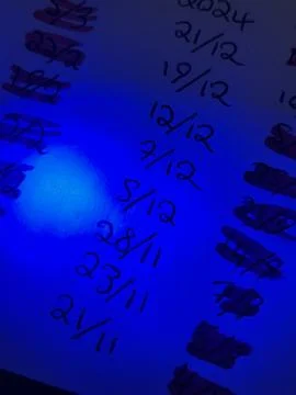 Highlighted Handwritten Dates on Paper Under Blue Light Effect Foto stock