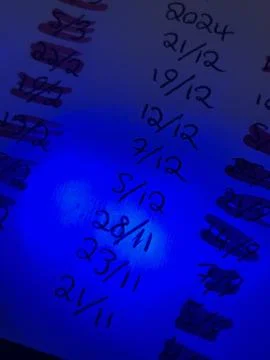 Highlighted Handwritten Dates on Paper Under Blue Light Effect Foto stock