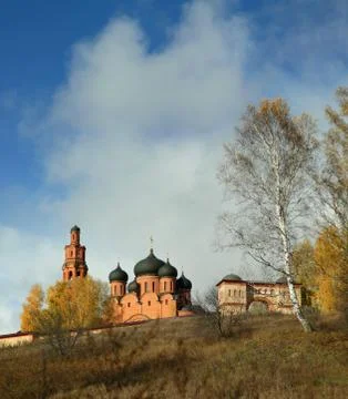 Highlighted Orthodox monastery on the background of clouds in autumn Stock Photos