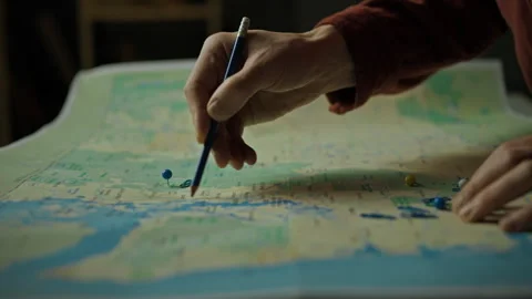 Highlighting locations on a map with colored pins and a pencil in a warm set Stock Footage 297705863