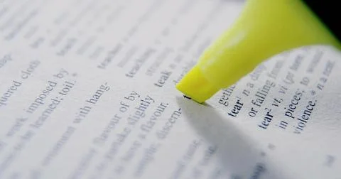 Highlighting printed word tear on dictionary page with neon yellow highlighter Stock Photos
