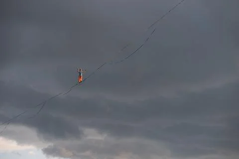 Highline against the dramatic sky. Rope walker at high altitude 写真素材