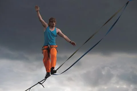 Highliner against a dramatic sky background. Slackline theme Stock Photos