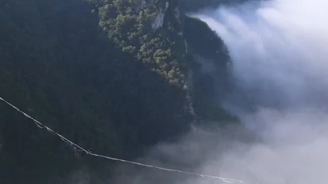 Highliner goes on a sling above the clouds. Stock Footage 137788487