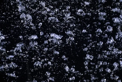 Highly concentrated tiny bubbles forming into larger masses as they rise in dark Stock Footage 86919414