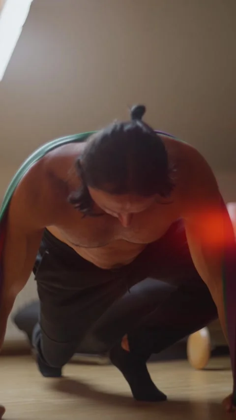 A highly focused individual is engaging in a strength exercise routine using Stock Footage 305245210
