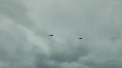 Highly in the sky against clouds two military Mi-8 Hip helicopters fly Stock Footage 12689401