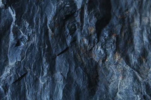 Highly textured dark grey stone surface showing vertical ridges and rugged .. Stock Photos
