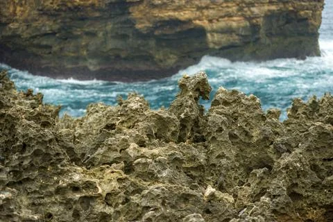 Highly textured, sharp volcanic rock formations on a rugged shoreline. Stock Photos
