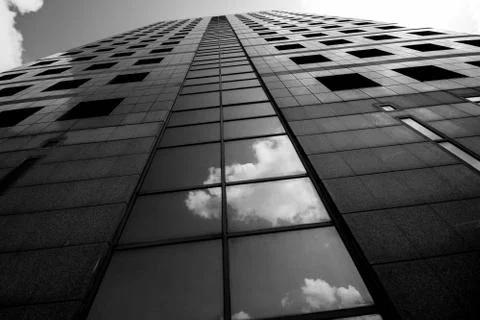 A highrise building with a reflection of clouds Stock Photos
