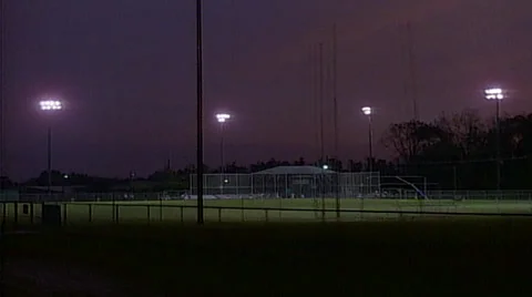 Highschool baseball game at dusk tracking shot from right to left Stock Footage
