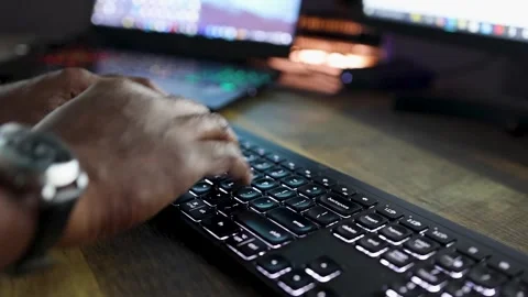 Hight resolution video of man of color's hands typing on a lit keyboard Stock Footage 289409293