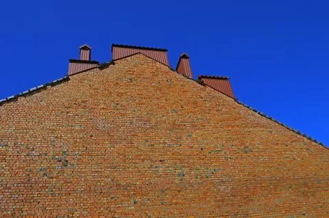 Hight rough brick wall in background clear blue sky. Large space for writing Stock-Fotos