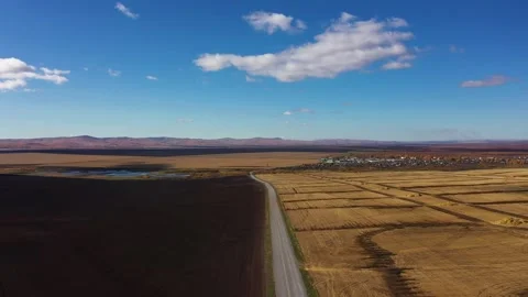 Highway between arable land and farmland on a sunny autumn day, aerial view Stock Footage 261166395