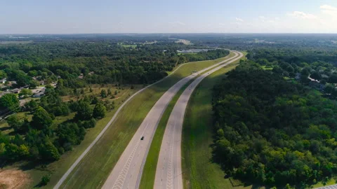 Highway between green grass and trees flyover in slow motion Stock Footage 302917790