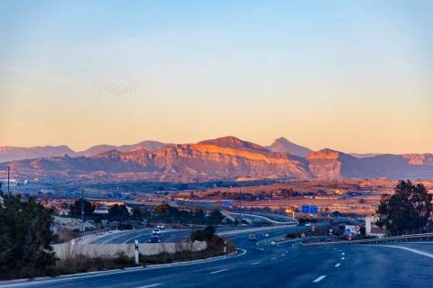 Highway between mountains in the evening Stock Photos