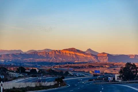 Highway between mountains in the evening Stock Photos