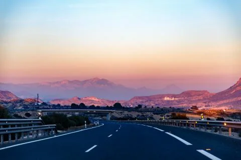 Highway between mountains in the evening Stock Photos