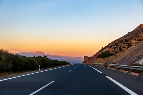 Highway between mountains in the evening Stock Photos