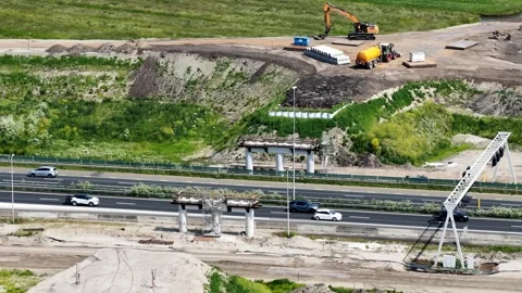 Highway bridge construction site with heavy machinery and traffic Stock Footage 335993102
