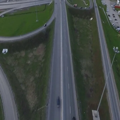 Highway with a circular intersection at which the traffic flow is going Stock Footage 69575026