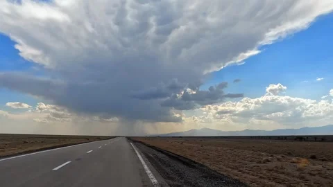A highway with clouds in the sky and mountains in the background Stock-Footage 317386311
