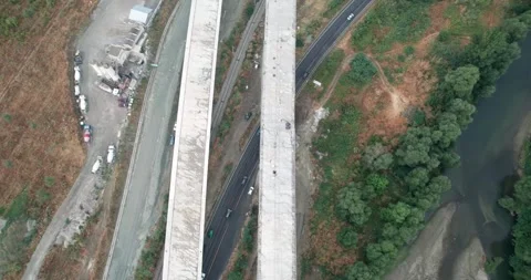 Highway construction site with bridge is shown in the air with a road and tra Video stock 347175954