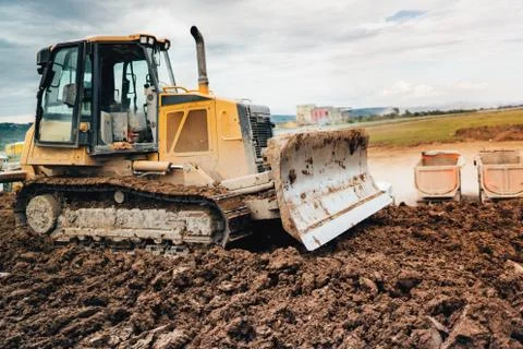 Highway construction site development with bulldozer moving earth, soil Stock Photos