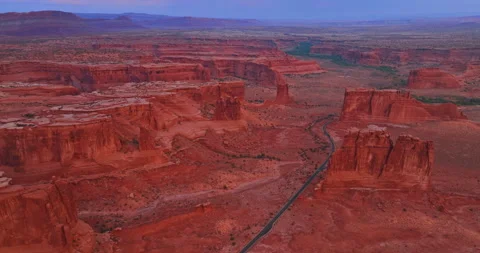 Highway going through the huge desert among the red canyons. Aerial perspective Stock Footage 317559063