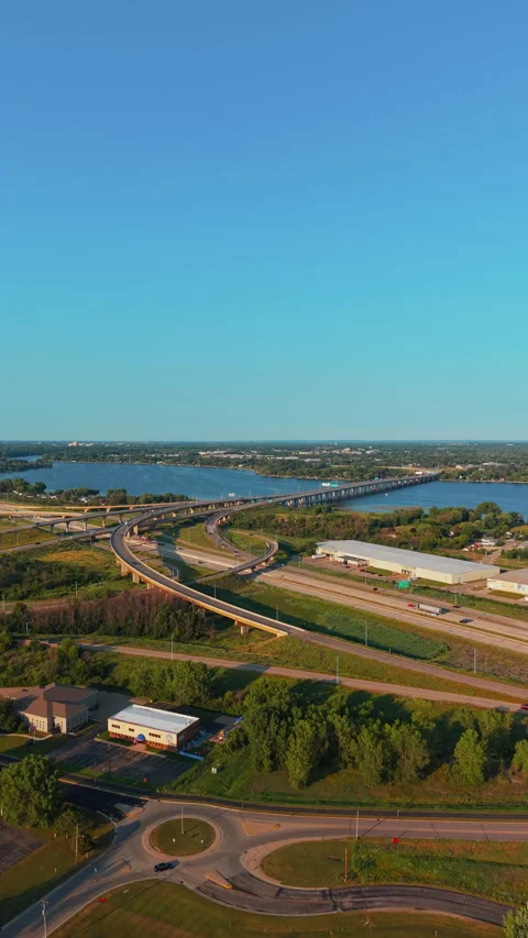 Highway Interchange and River Bridge at Sunset in Green Suburban Landscape Stock Footage 341329890