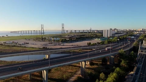 Highway interchange with distant suspension bridge under bright blue sky Stock Footage 345226695