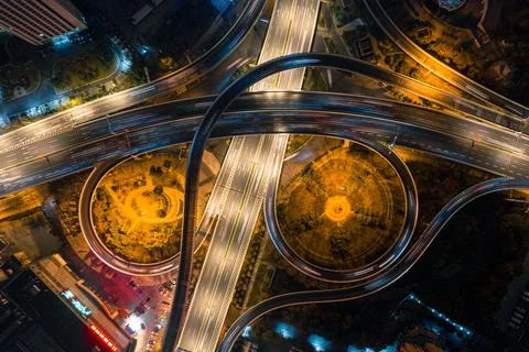 Highway intersection at night, illuminated with light bulbs and traffic Stock Photos